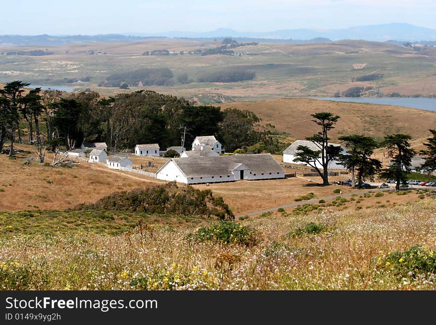 White Farm Buildings Surrounded By Pasture