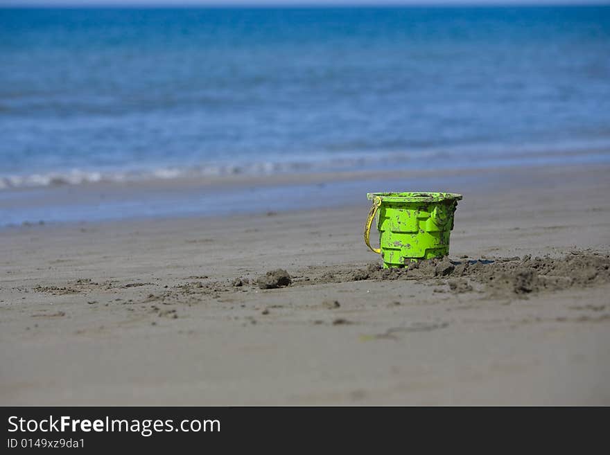 Toy on a sandy beach with the ocean in the background on a sunny day. Toy on a sandy beach with the ocean in the background on a sunny day.