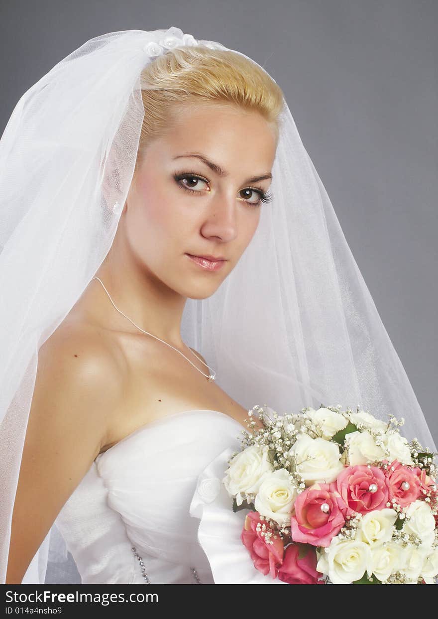 Portrait of beautiful bride on grey background studio shot