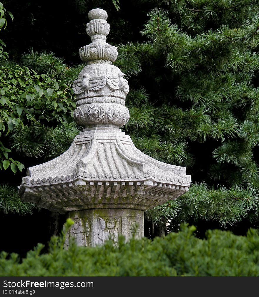 The top of a monument at a Korean temple peeks out from a grove of trees. The top of a monument at a Korean temple peeks out from a grove of trees.