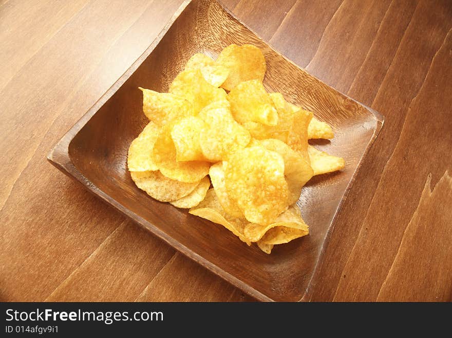 Crunchy potato chip in a wooden bowl. Crunchy potato chip in a wooden bowl