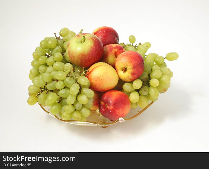 An isolated vintage glass plate loaded with fresh fruit. An isolated vintage glass plate loaded with fresh fruit