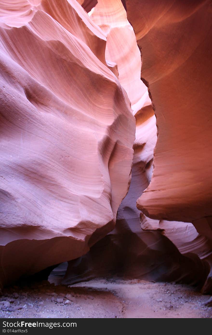 Hiking trail within the slot canyon showing the scale and monumental rock formations hanging over the trail. Hiking trail within the slot canyon showing the scale and monumental rock formations hanging over the trail