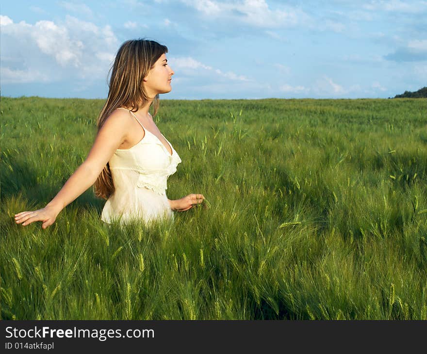 Beautiful young woman in green field relaxing. Beautiful young woman in green field relaxing