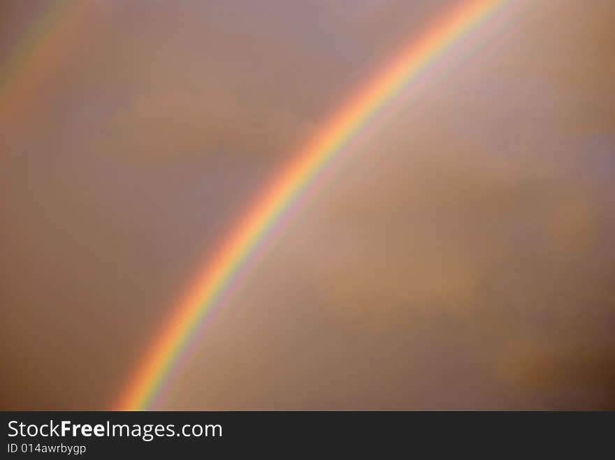 Colorful bright rainbow set against stormy sky. Colorful bright rainbow set against stormy sky