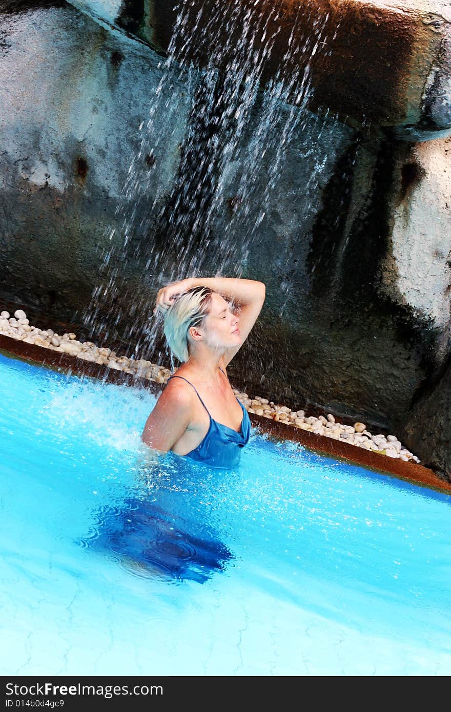 Beautiful woman in a swimming pool at a resort.