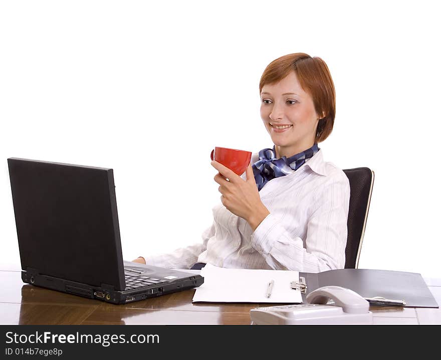 Young beautiful businesswoman with a red cup behind a desktop. Portrait in a high key. Young beautiful businesswoman with a red cup behind a desktop. Portrait in a high key.