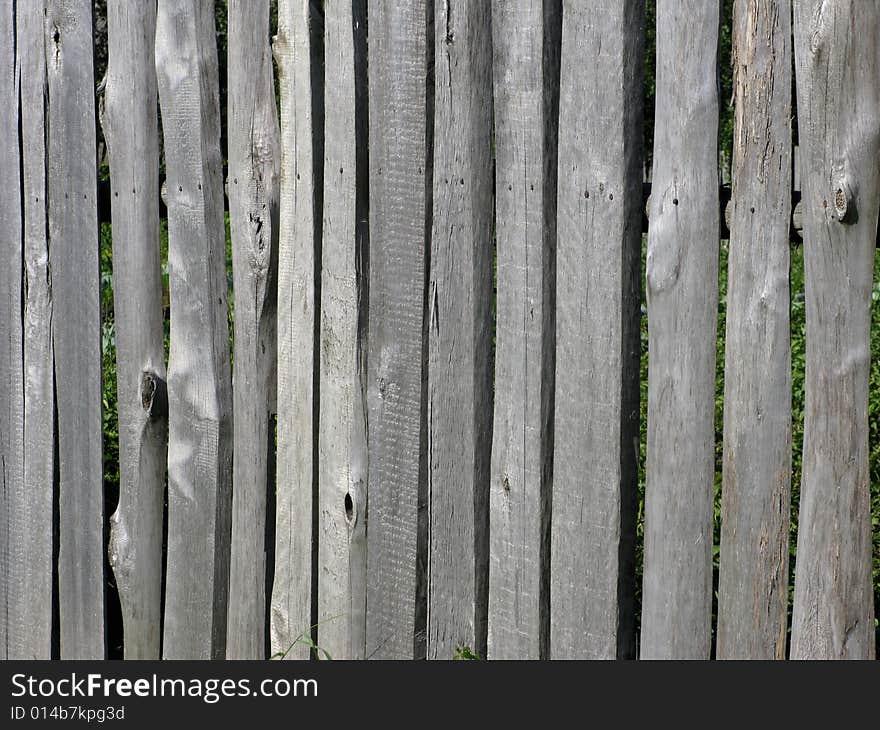 Fragment of old uncolored wooden slab fence. Fragment of old uncolored wooden slab fence