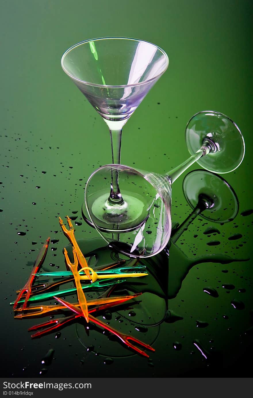 Two cocktail glasses on green background