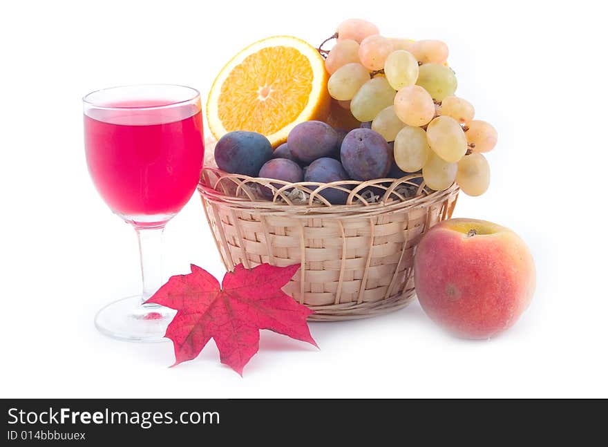 Grapes in a yellow basket and wine with maple leaves on a white background