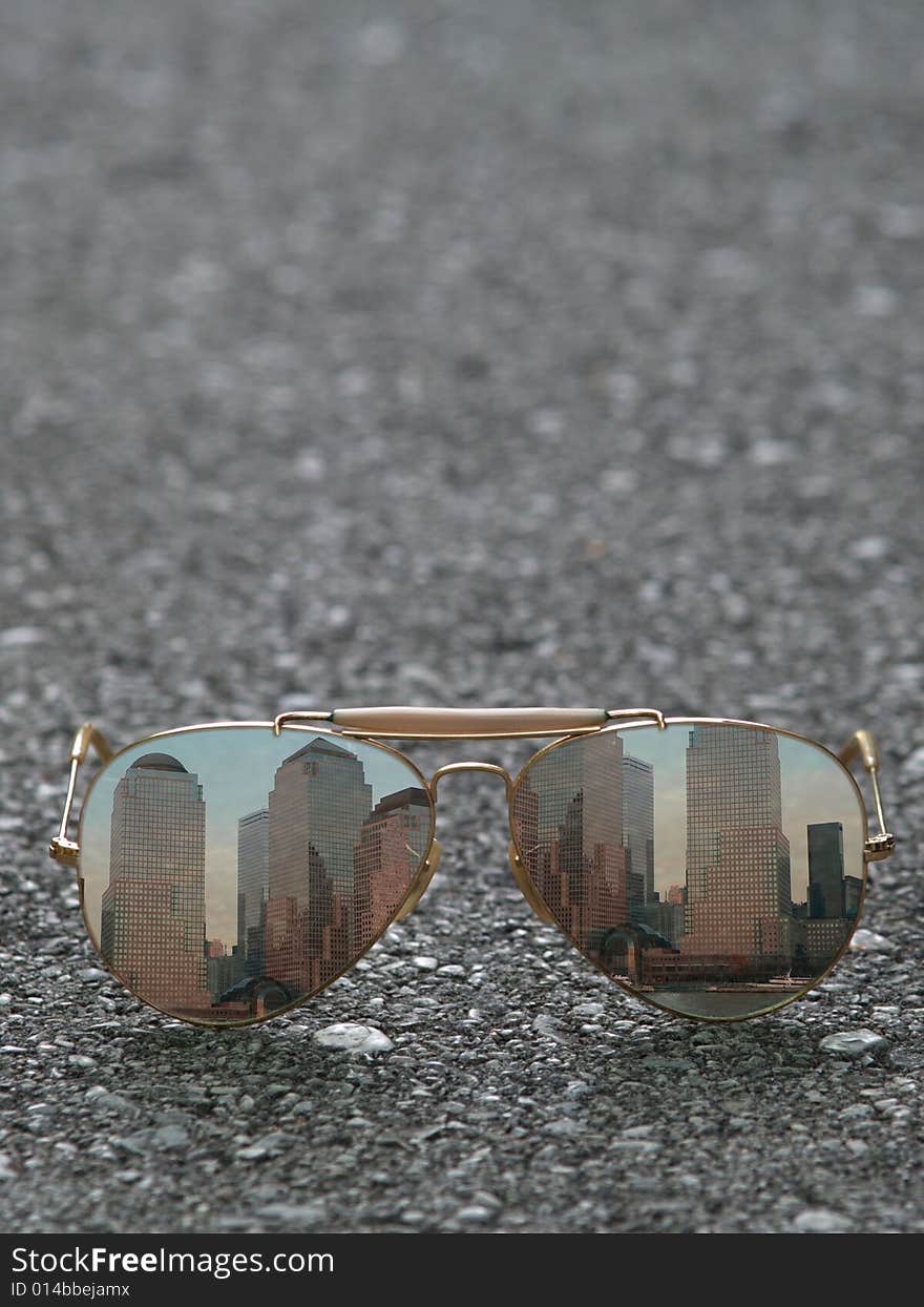 Sunglasses with the reflection of skylines on asphalt