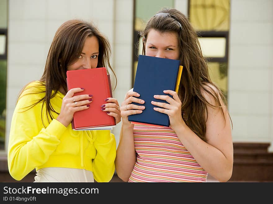 Two cute students hold books in their hands