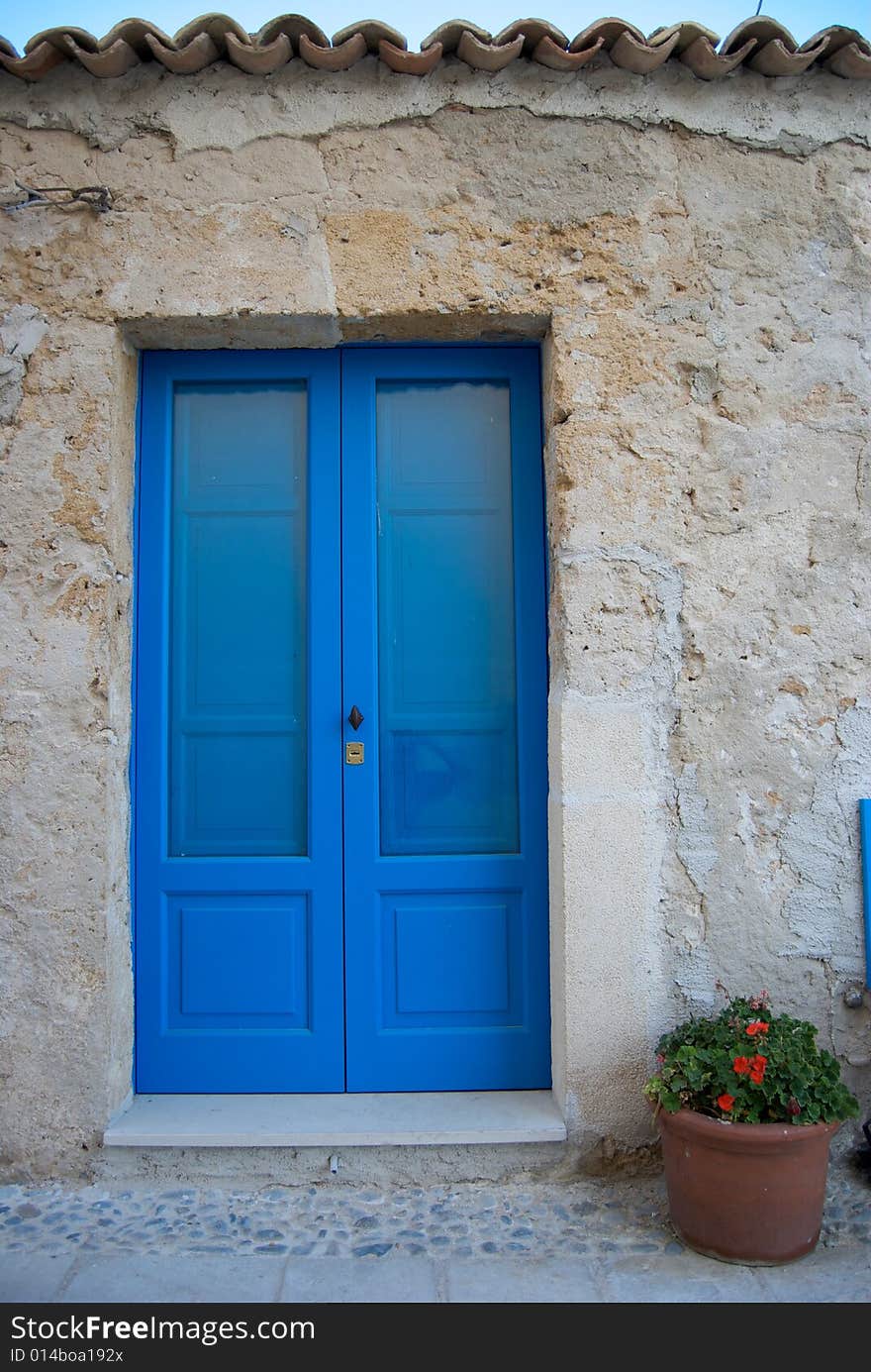 The stone house of the fisherman has one blue door. Photo taken in a baroque village of a small country near Syracuse. The stone house of the fisherman has one blue door. Photo taken in a baroque village of a small country near Syracuse.