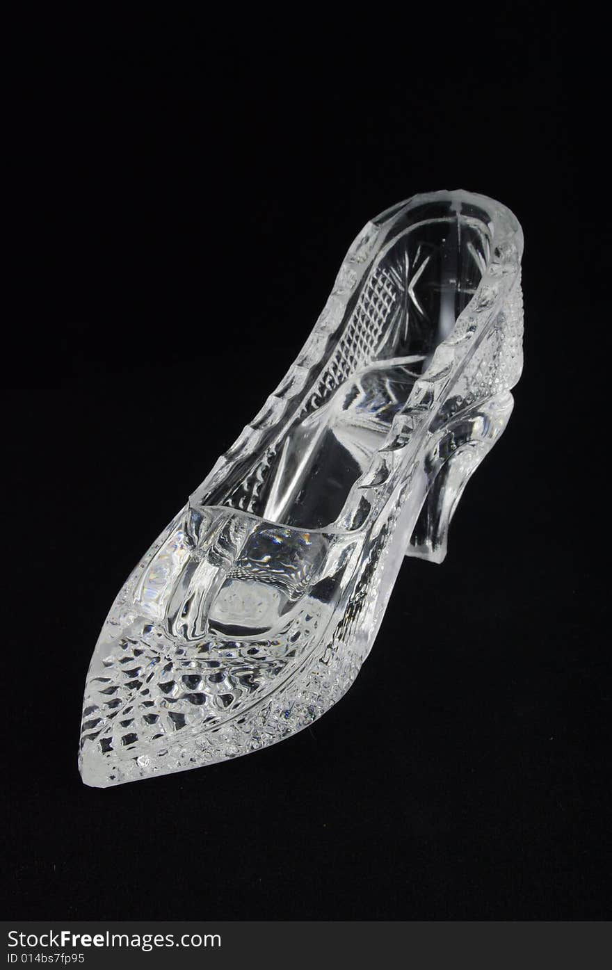 Crystal glass slipper over black background