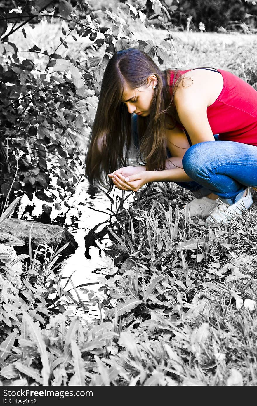 Young woman in color contrasting with dead nature surrounding her.