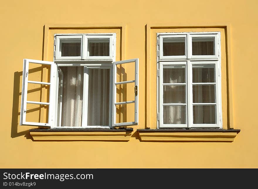 Two windows on yellow wall