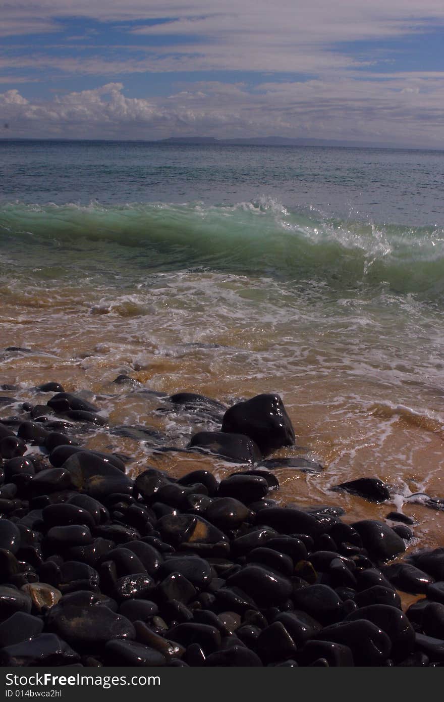 Rocky beach with a nice wave breaking on a cloudy day