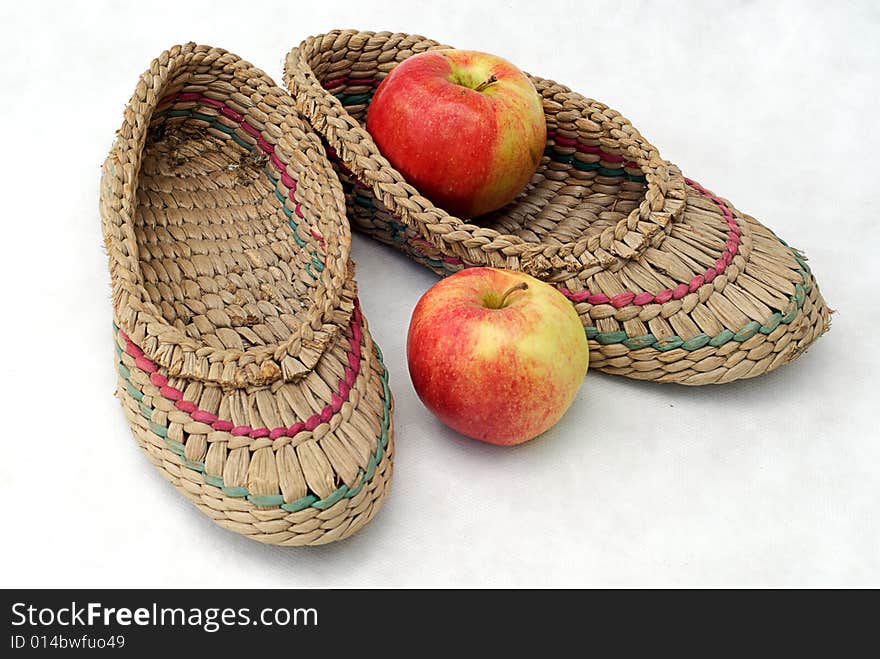 Bast shoes and two apples