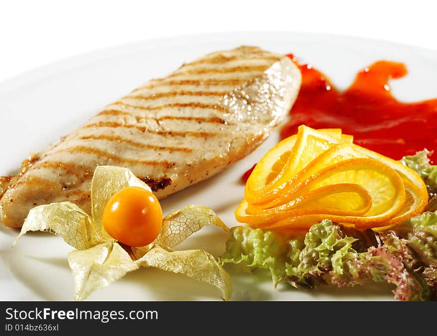 Chicken Grilled Steak with Sauce and Orange Slice. Isolated on White Background. Chicken Grilled Steak with Sauce and Orange Slice. Isolated on White Background