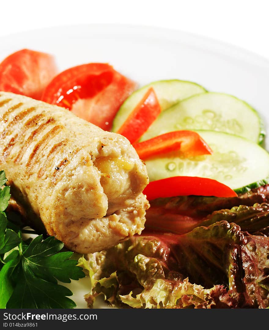 Pork (or Beef) Grilled Roll with Greens and Vegetables on a Plate. Isolated on White Background. Pork (or Beef) Grilled Roll with Greens and Vegetables on a Plate. Isolated on White Background