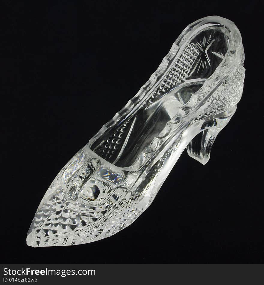 Crystal glass slipper over black background