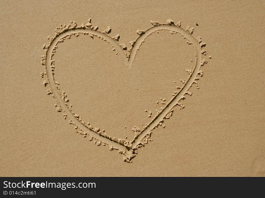 Heart drawn into sand as background