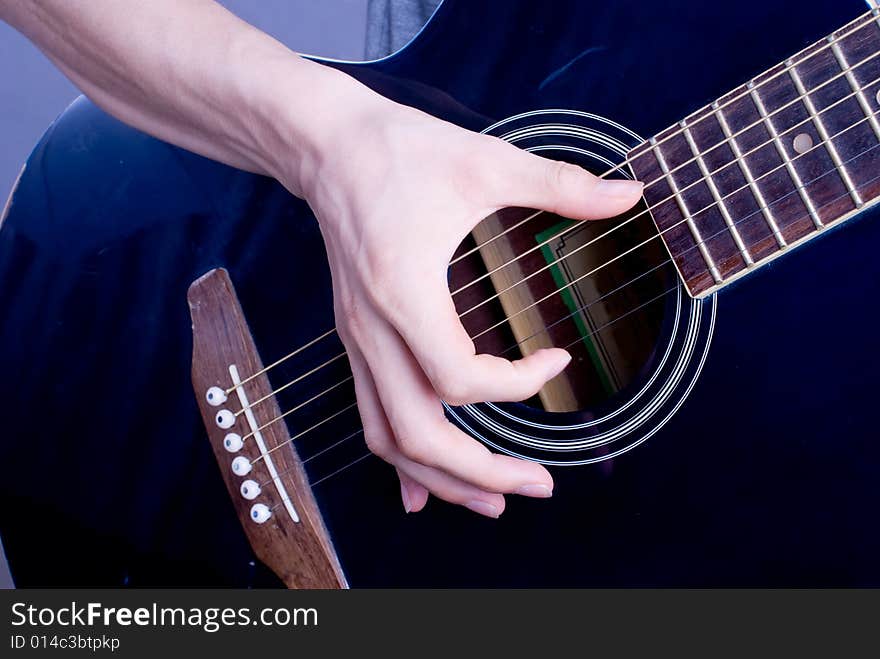 Male hand with classical antique wooden guitar