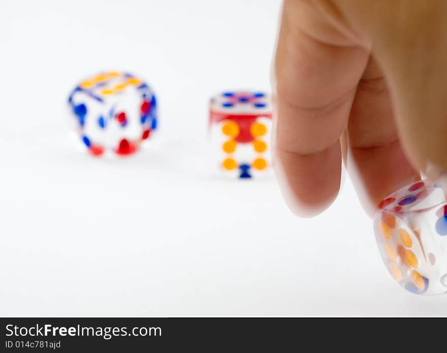 Hand rolling a dice against two thrown dice. Hand rolling a dice against two thrown dice