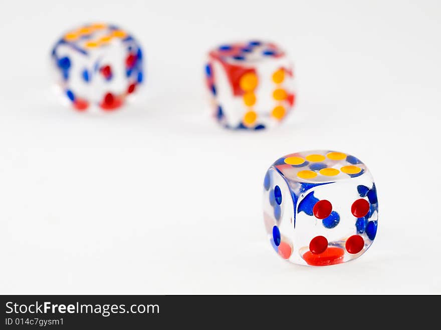 Still life of three plastic dice on white background