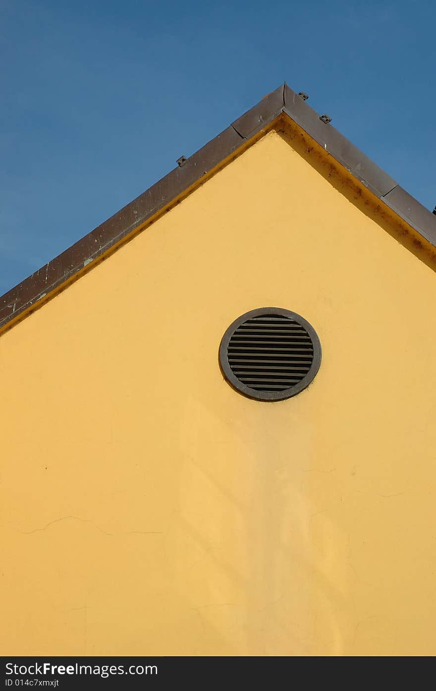 Round window on the yellow facade