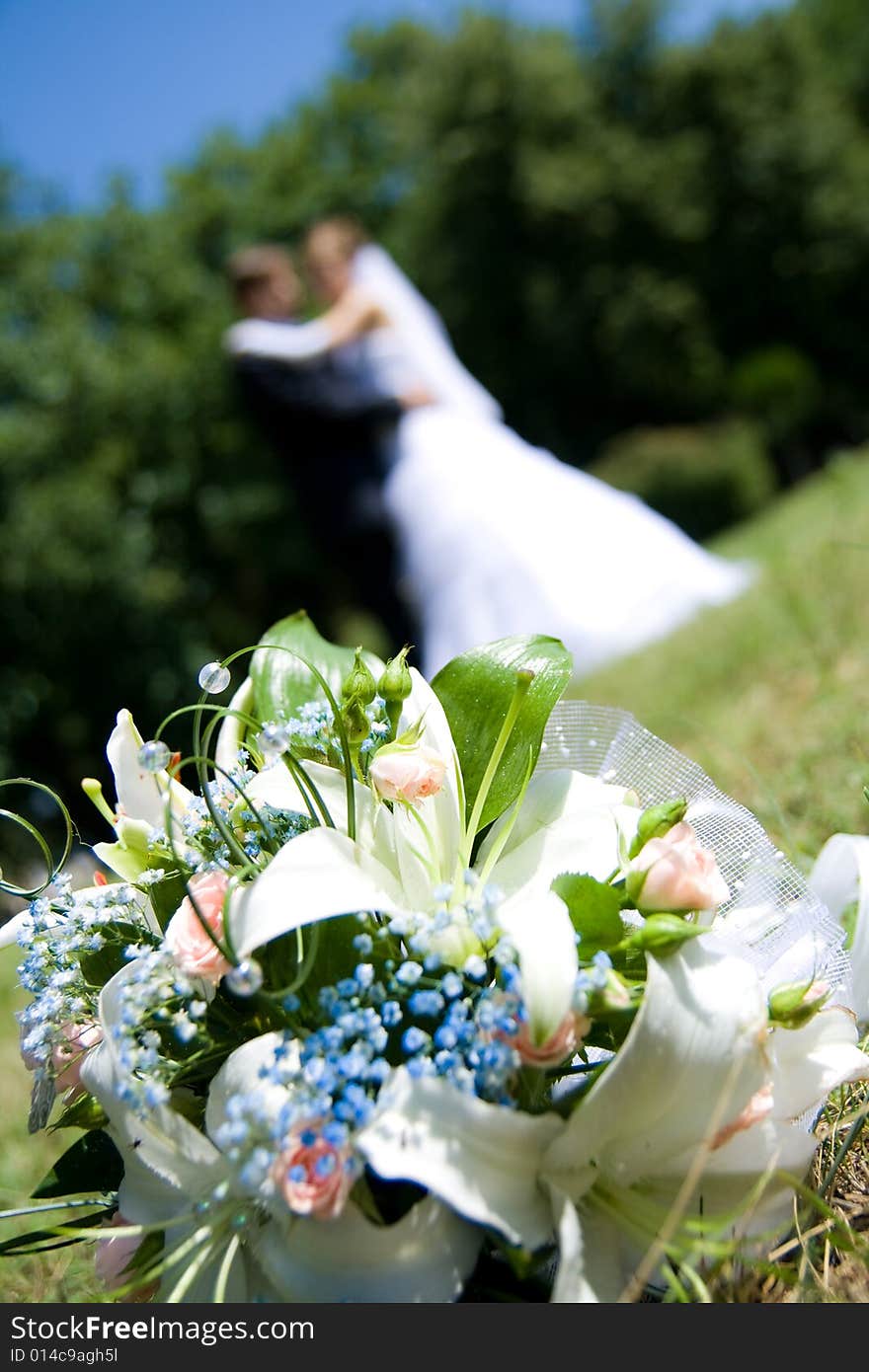 Bunch of white roses and newly-weds on a green background. Bunch of white roses and newly-weds on a green background