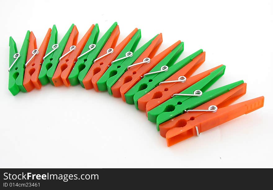 Green and red clothes-pegs isolated over white background.