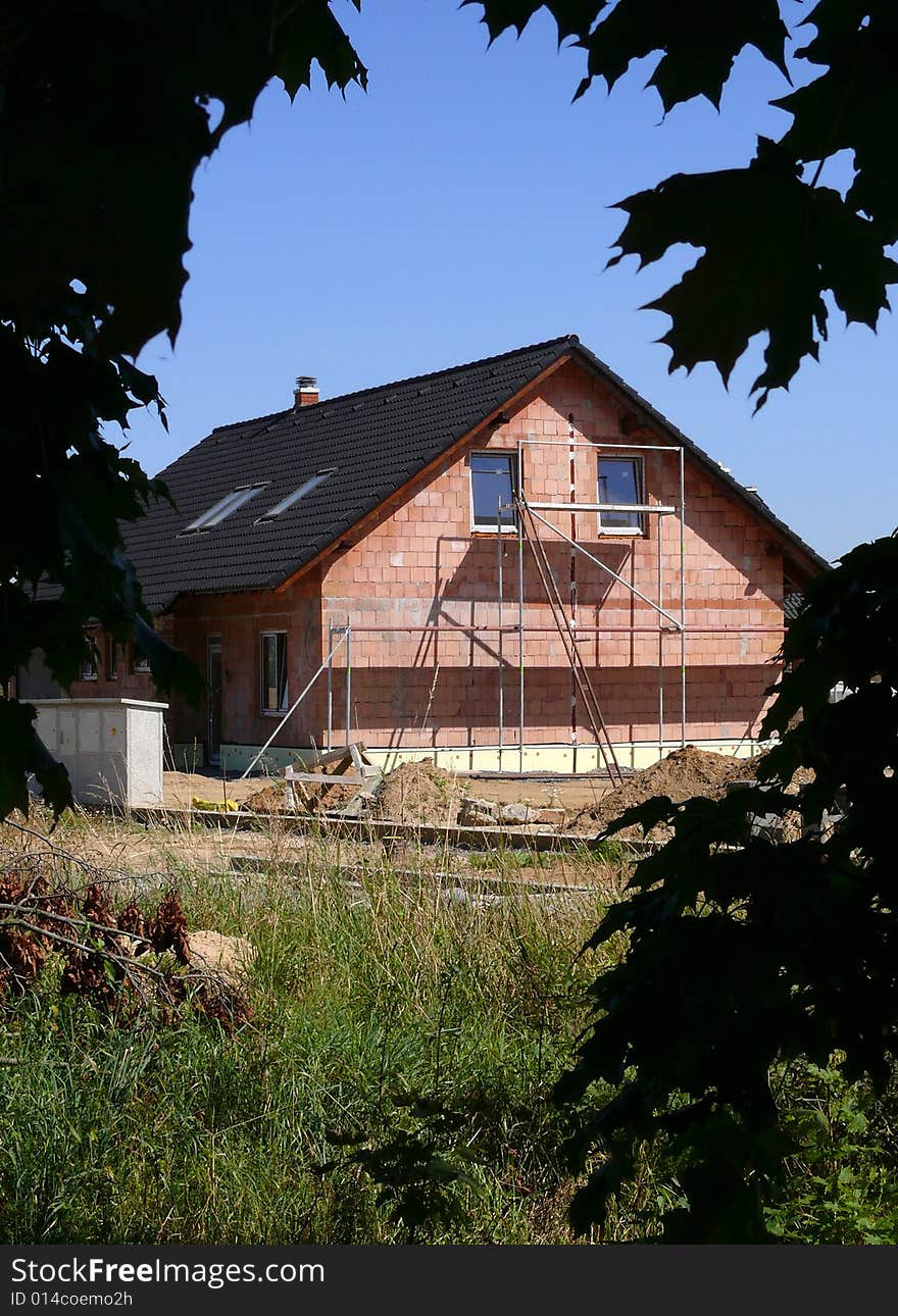 House construction, grass, silhouette leaves and blue sky