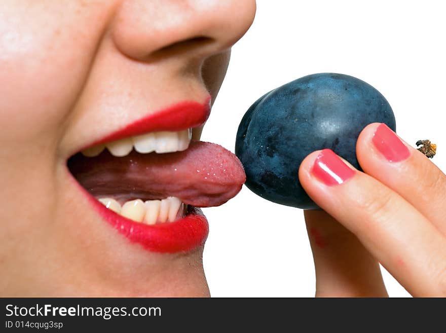 Girl, holding a plum on the tip of her tongue, just before taking a bite. Girl, holding a plum on the tip of her tongue, just before taking a bite