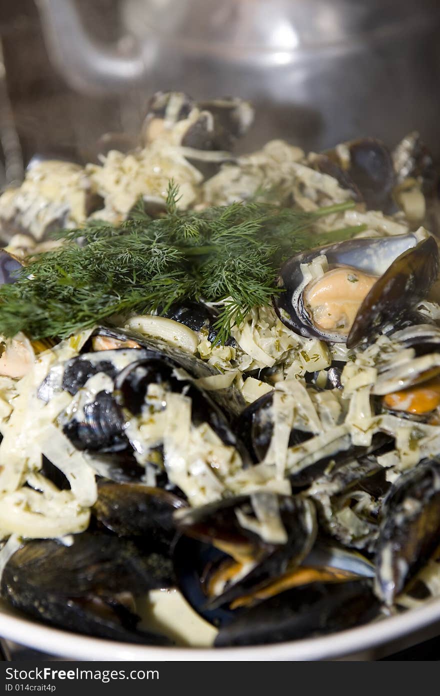 Freshly cooked black mussels, still in the shell, presented in a bowl with delicious cream dressing and garnish. Freshly cooked black mussels, still in the shell, presented in a bowl with delicious cream dressing and garnish.