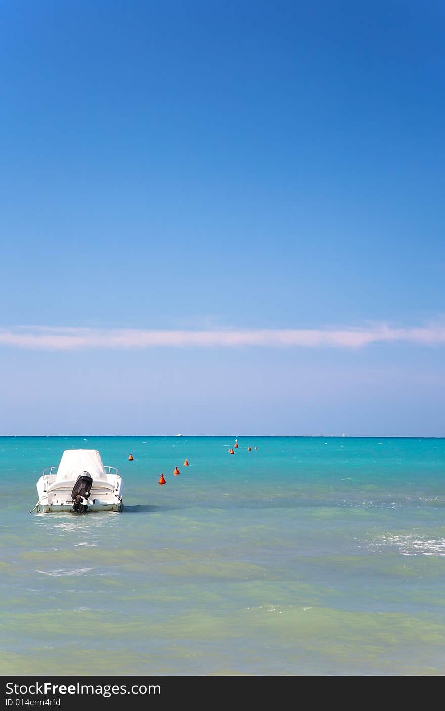 Tropical seascape with a standing white speedboat; vertical frame. Tropical seascape with a standing white speedboat; vertical frame