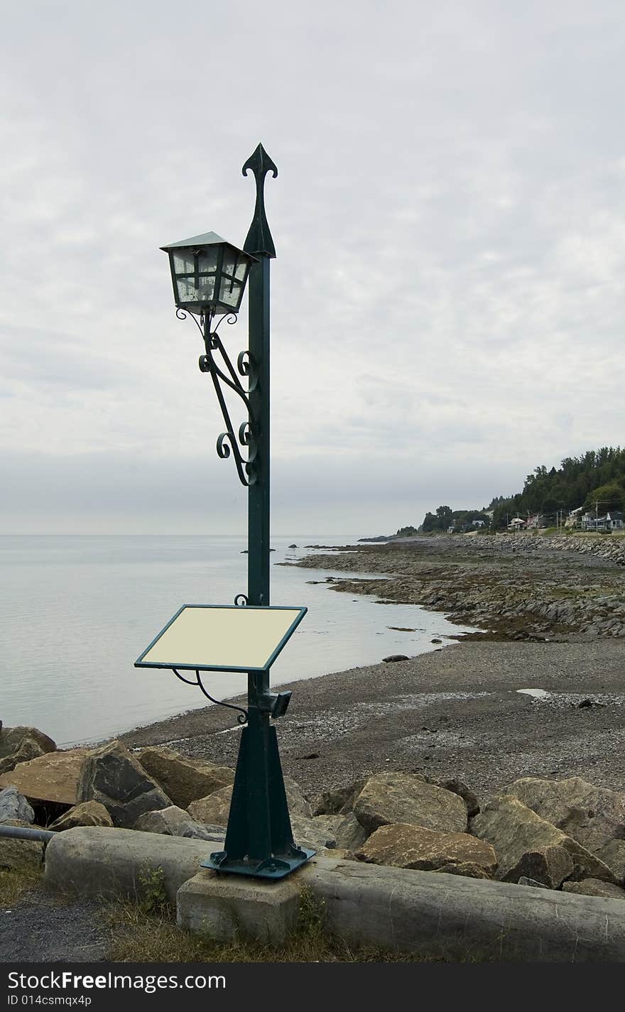 A lantern on the seashore with a blank sign that can be used to post a message. A lantern on the seashore with a blank sign that can be used to post a message