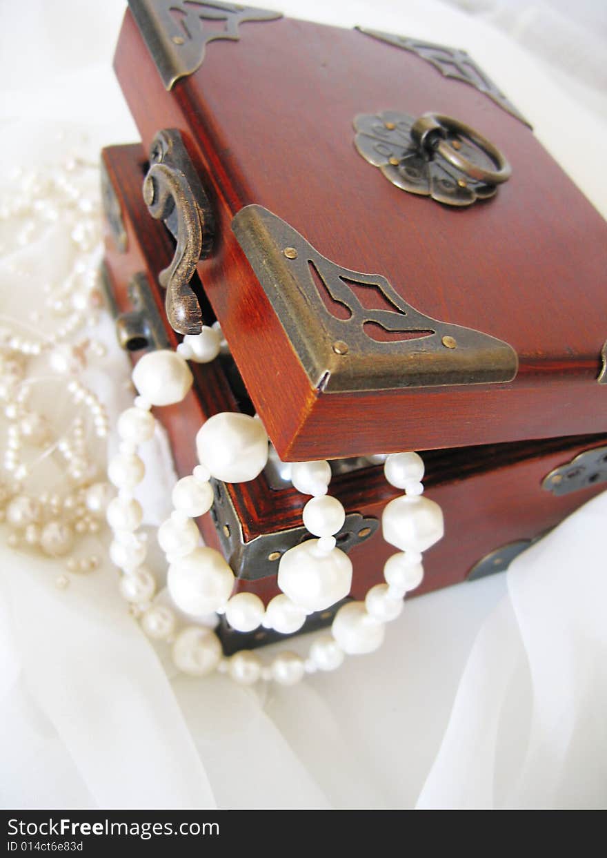 Casket of of pearl necklace on white material. Casket of of pearl necklace on white material