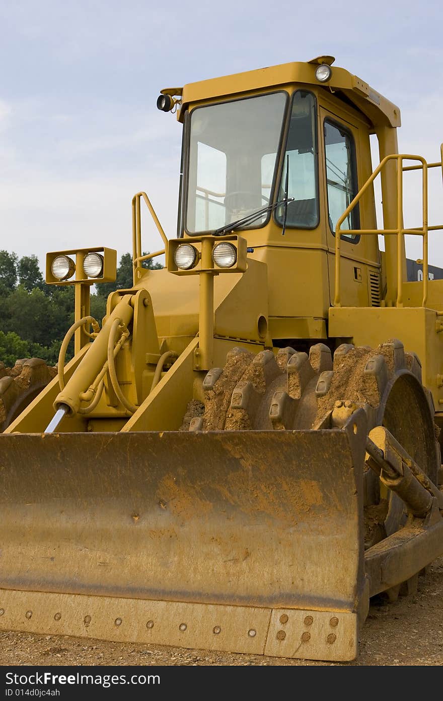 Closeup of a soil compactor with the sky as a background.