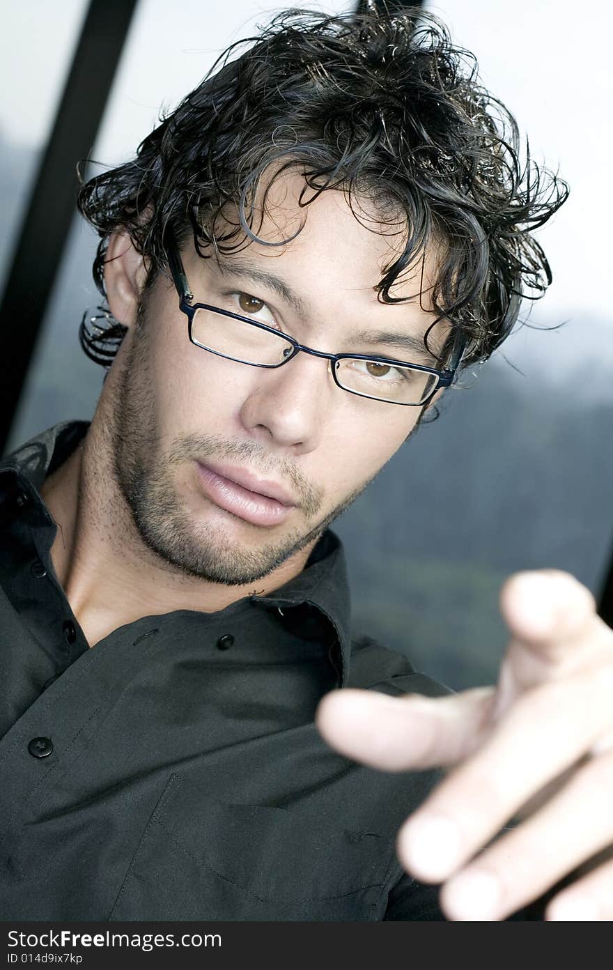 Young man with glasses pointing at the camera. Young man with glasses pointing at the camera