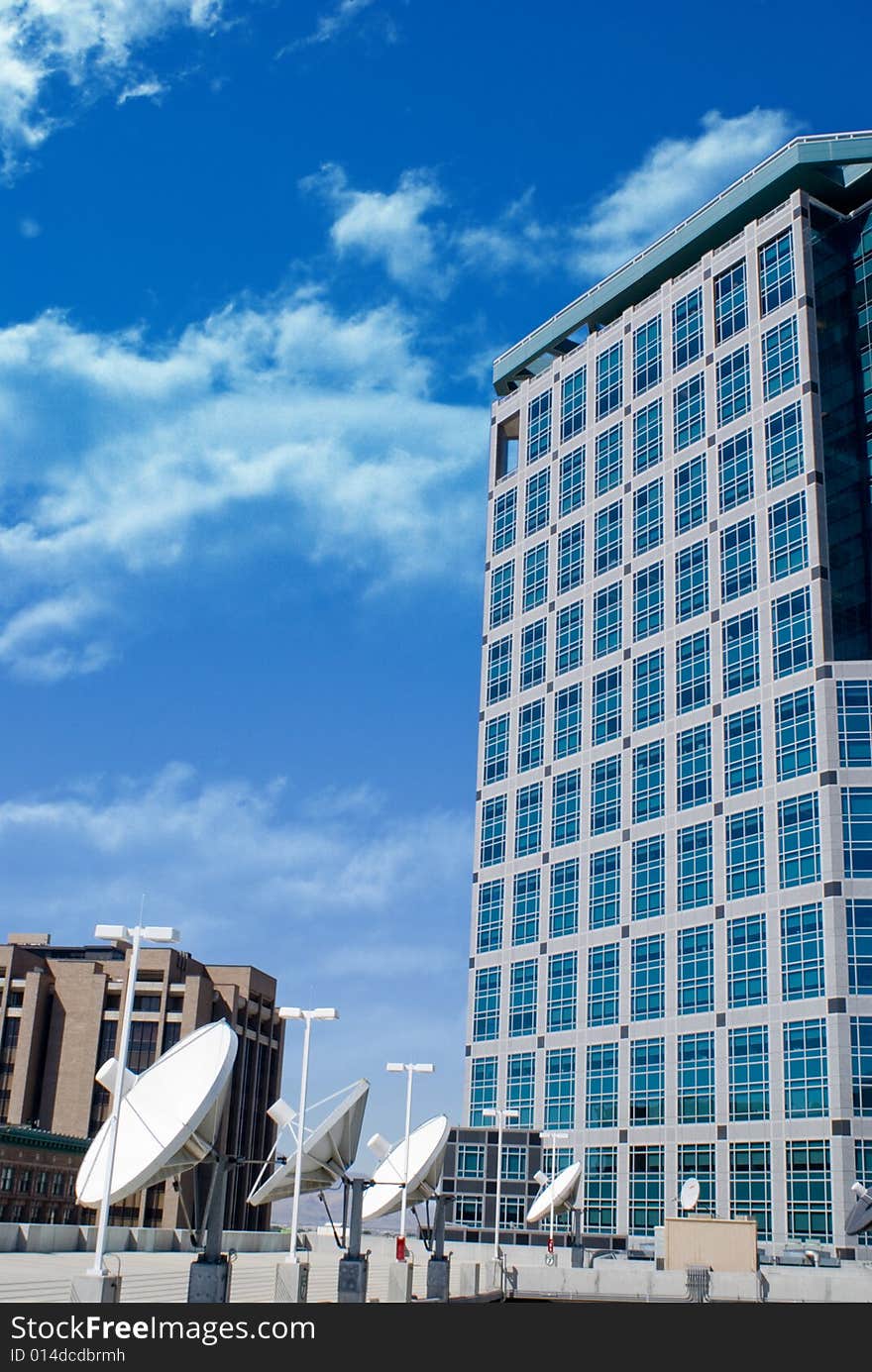 A modern building with rows of satellites in the foreground.