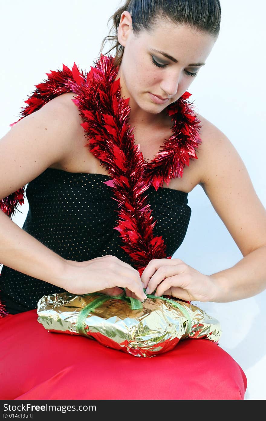 Pretty brunette woman opening a Christmas present. Pretty brunette woman opening a Christmas present.