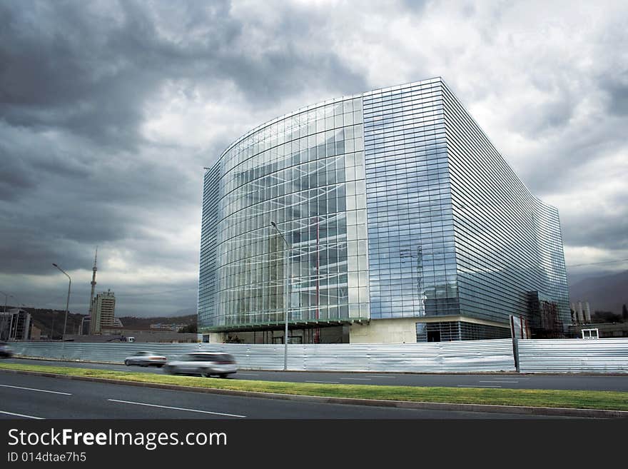 Modern glass business center with dramatic sky