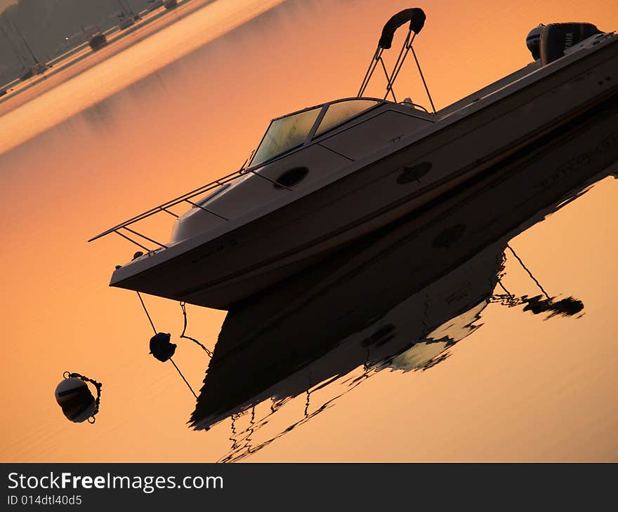 A simple boat and its reflection at sunrise in the bay of Oyster Point, NJ. A simple boat and its reflection at sunrise in the bay of Oyster Point, NJ