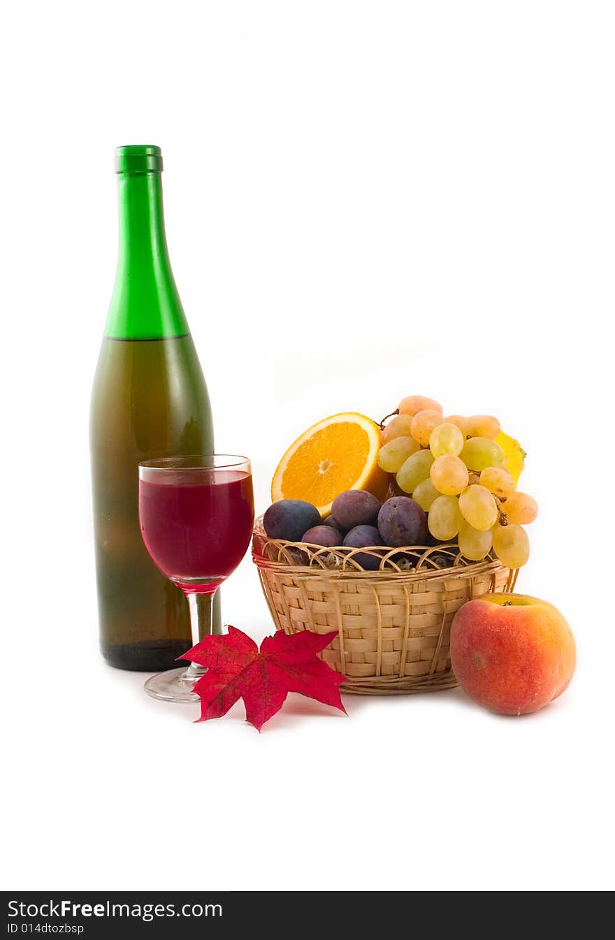 Bottle fault in a yellow basket and plums on a white background