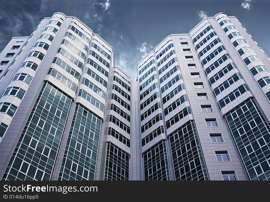 Modern glass business center with dramatic sky