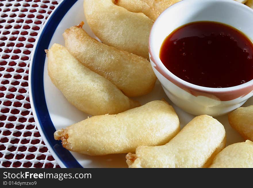 A platter of deep fried shrimp with plum sauce.