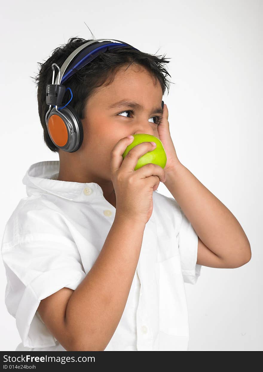 Asian boy biting into a green apple