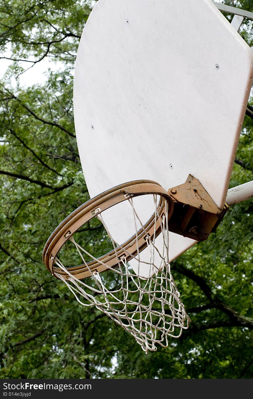 Worn basketball net and rim attached to a white backboard. Worn basketball net and rim attached to a white backboard