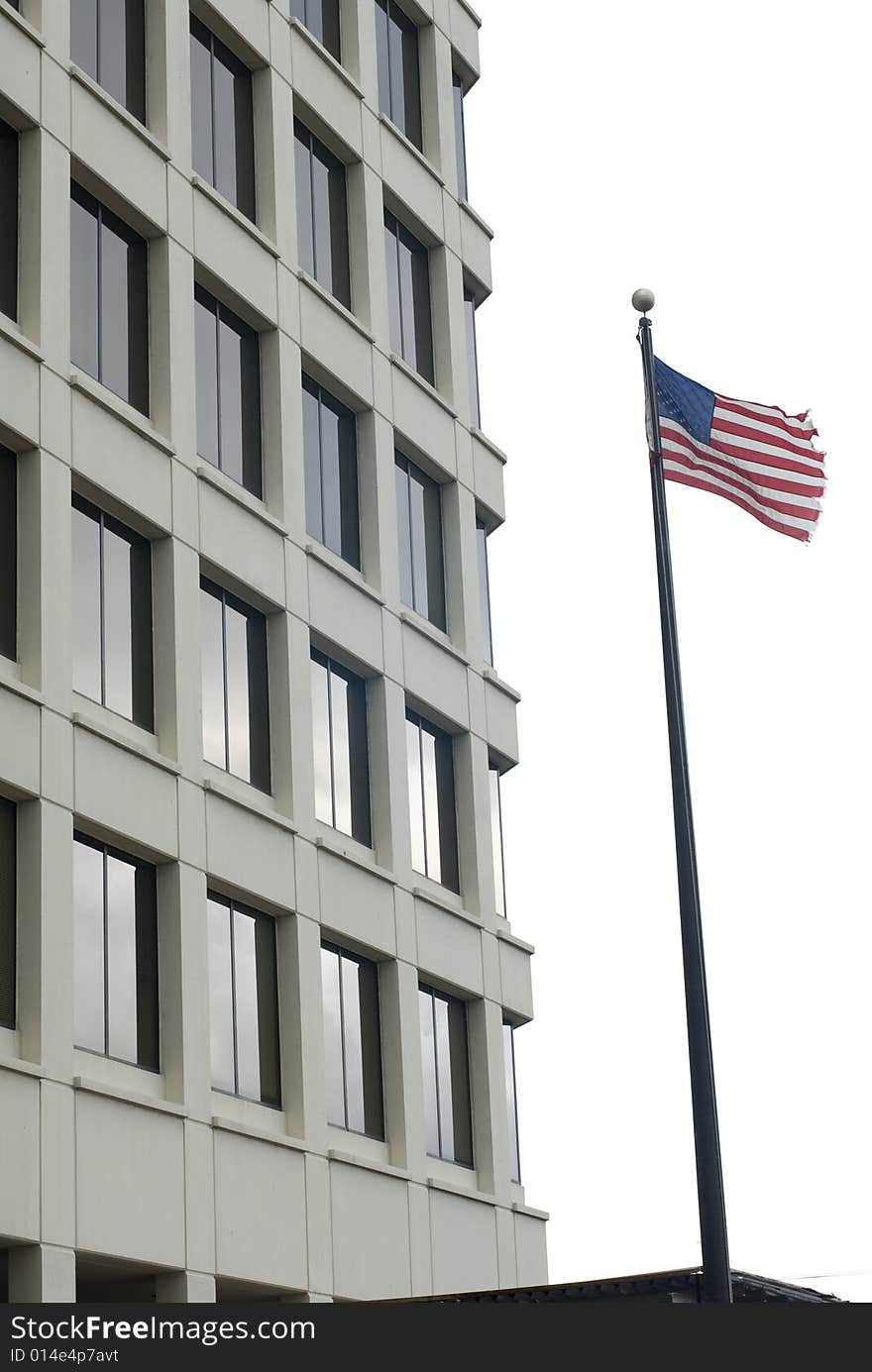 American flag waving outside of a tall cream building. American flag waving outside of a tall cream building